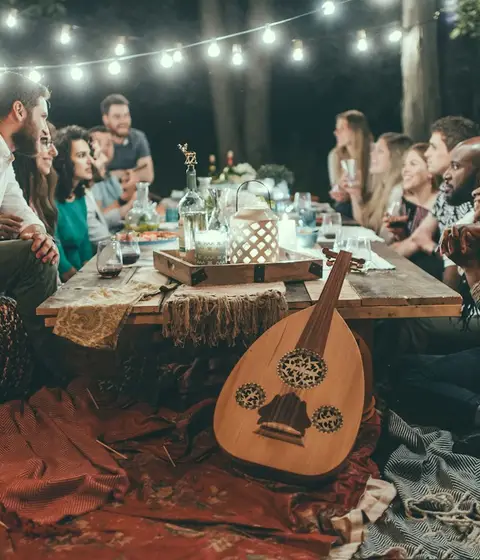 Friends sharing dinner outside under string lights